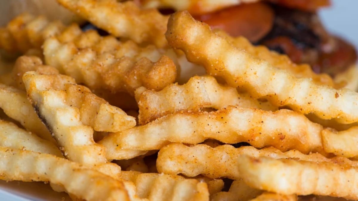 Golden crispy French fries being prepared using combined microwave and conventional frying technology
