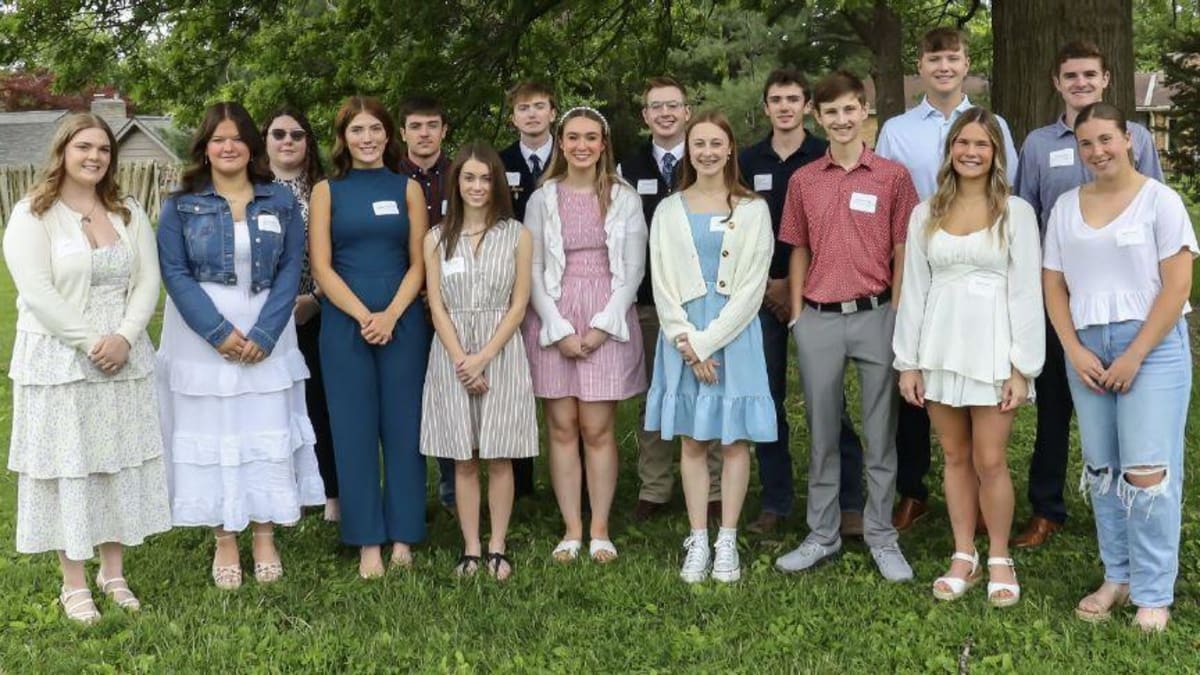 Sixteen smiling scholarship recipients standing together at Community Foundation award ceremony in Quincy