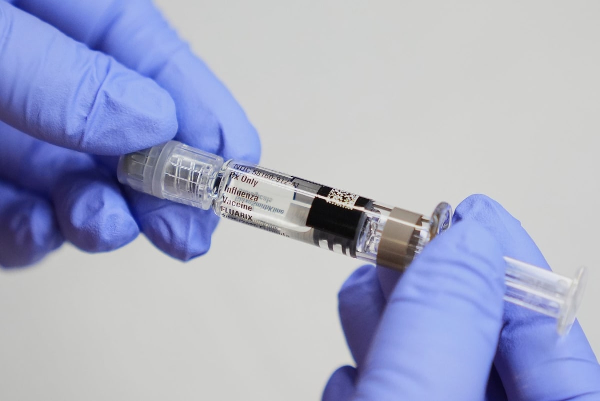 Doctor preparing vaccine dose for patient in medical office setting
