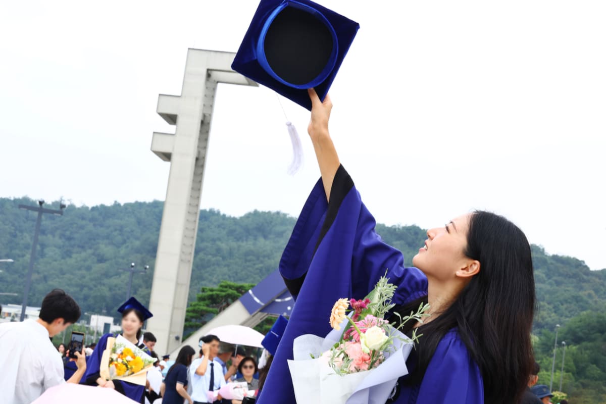 Seoul National University graduation ceremony with students celebrating in caps and gowns