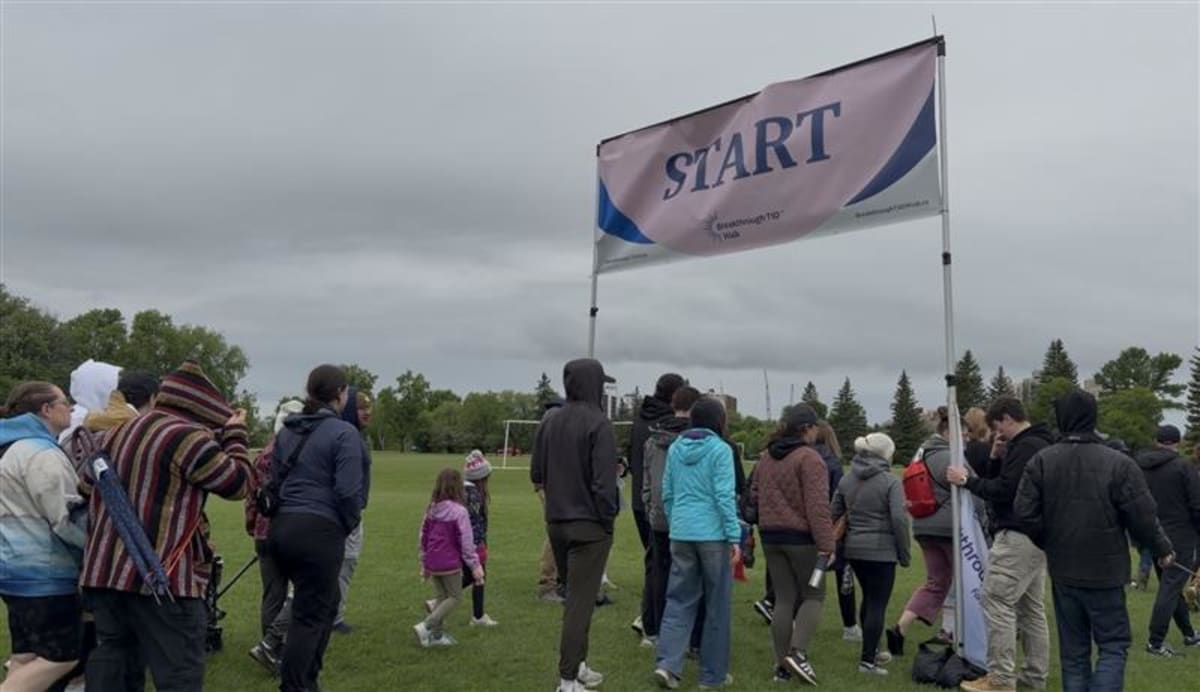Hundreds of people walking together through rainy weather at St. Vital Park for diabetes fundraiser