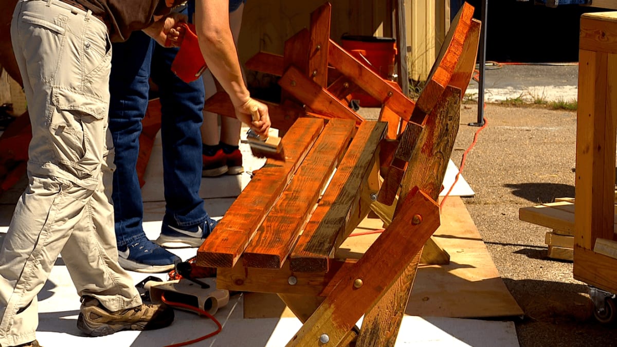 Volunteers building wooden benches outdoors for Asheville bus stops during community event