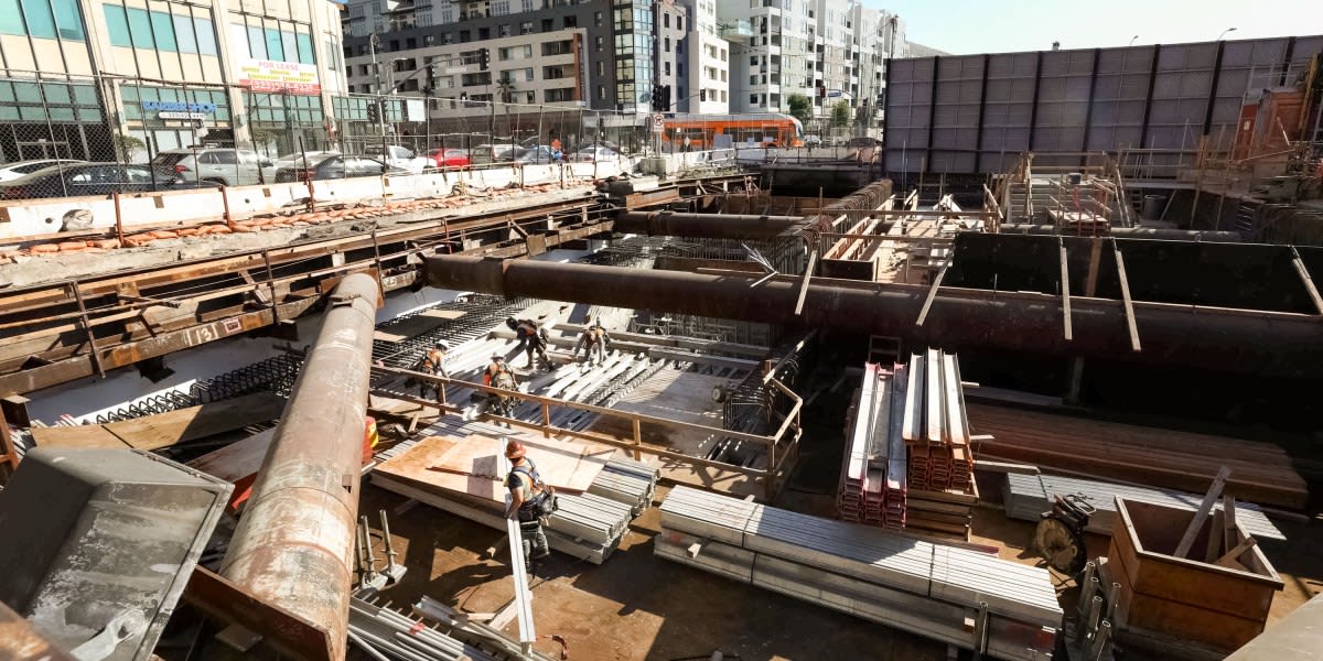 Modern LA Metro subway train pulling into newly constructed underground station with concrete walls