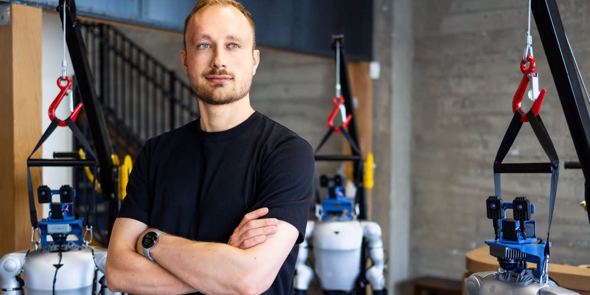 Humanoid robots hanging from ceiling racks in a San Francisco tech office workspace