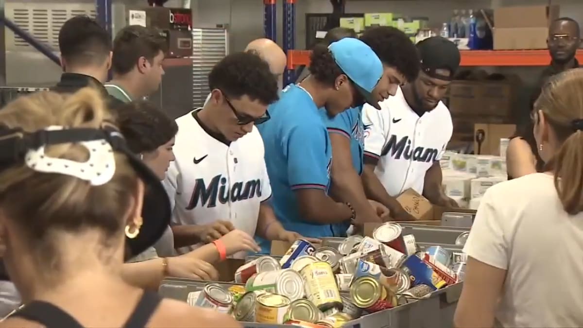 Miami Marlins baseball players and staff packing emergency relief supplies in warehouse