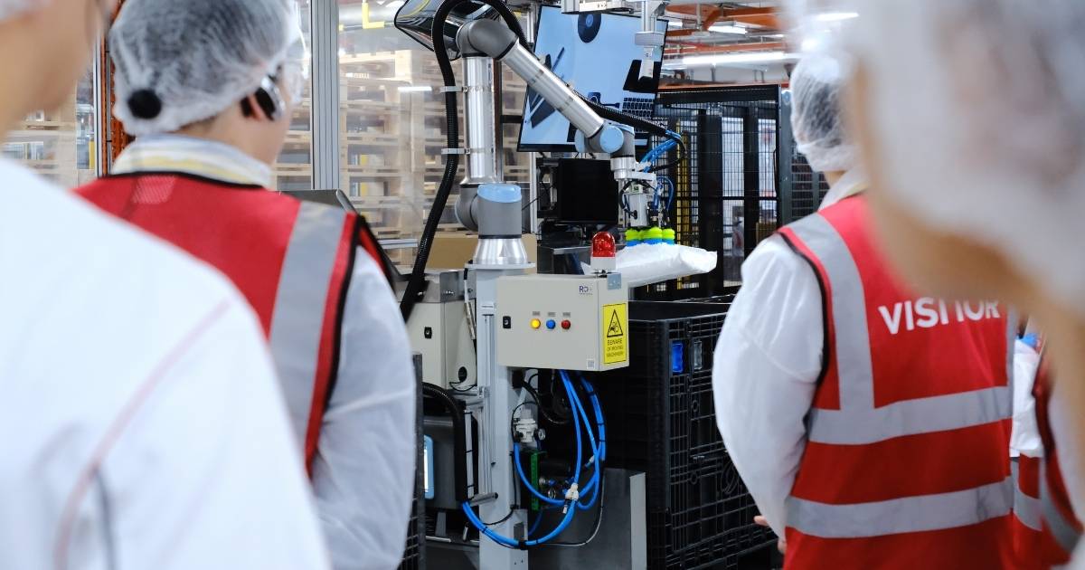 Robotic arms handling ingredient bags at Coca-Cola Singapore's automated manufacturing facility in Tuas