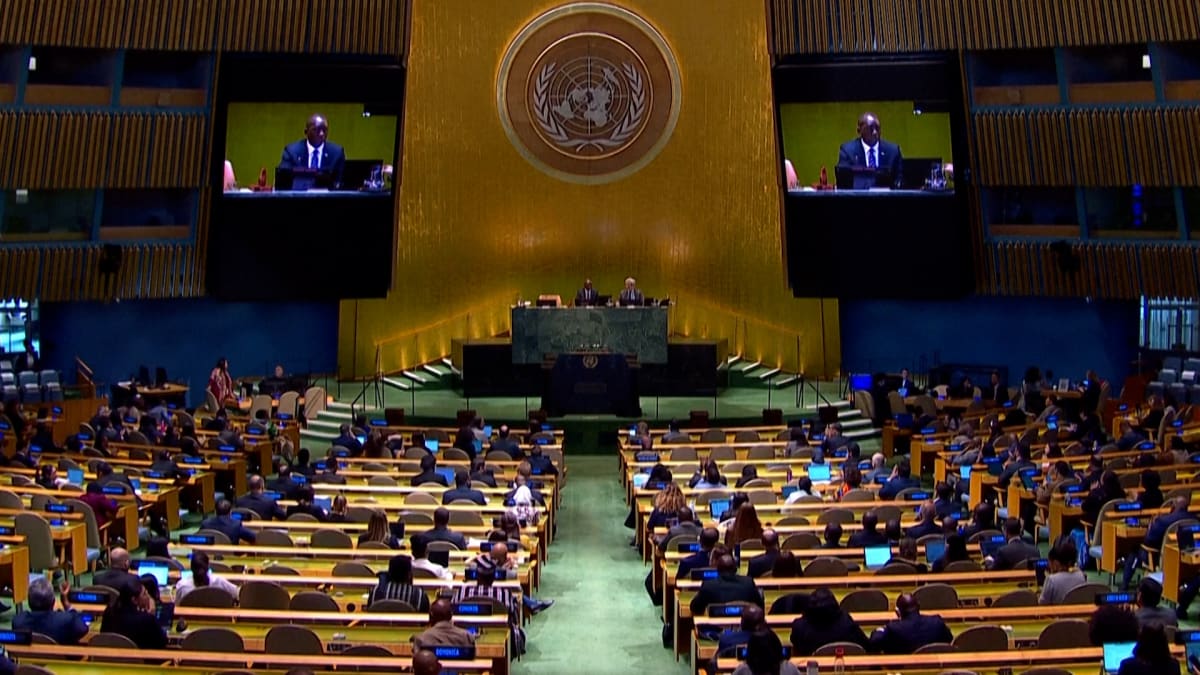 United Nations General Assembly hall with member nation flags and delegates convening
