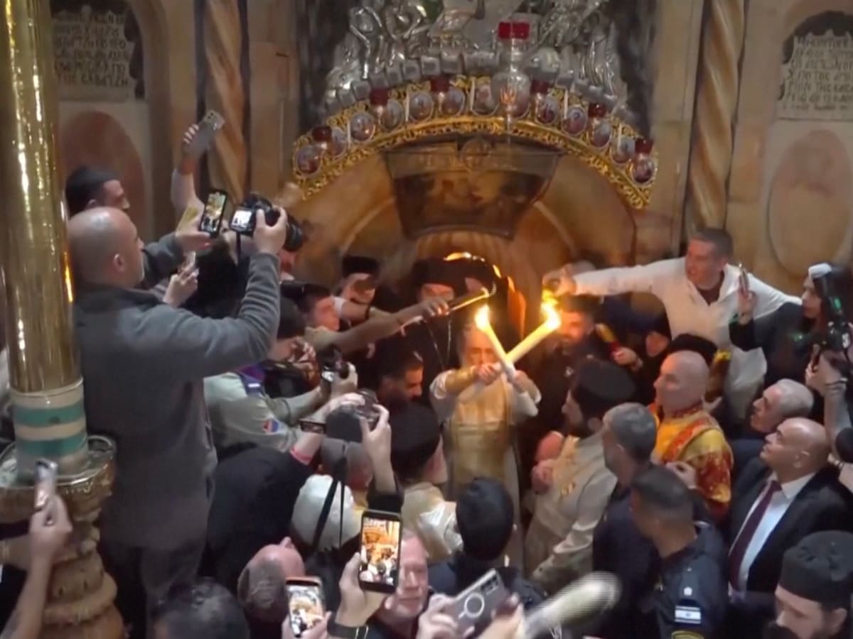 Orthodox Christian worshippers holding candles inside Jerusalem's Church of the Holy Sepulchre during Easter ceremony