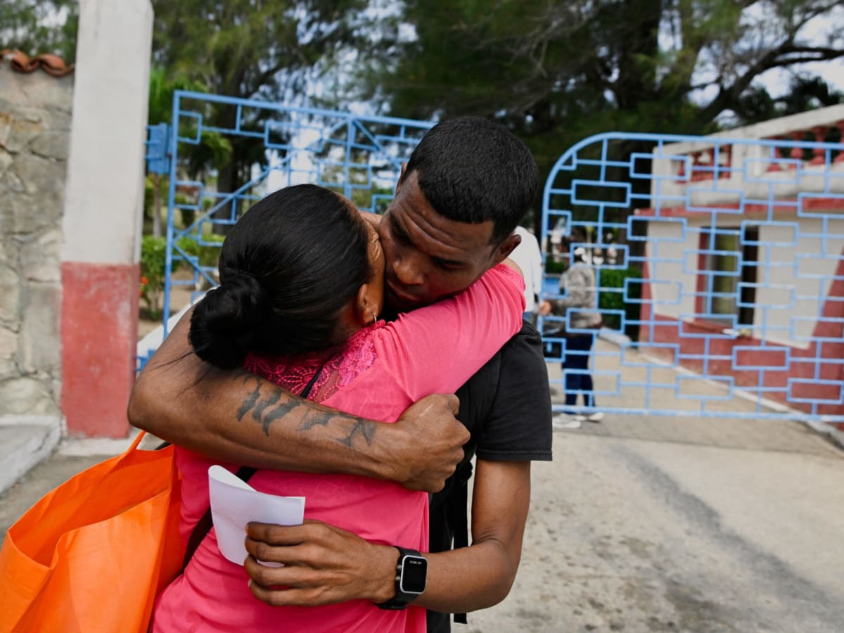 ** Families embracing outside Cuban detention facility during emotional prisoner release reunion