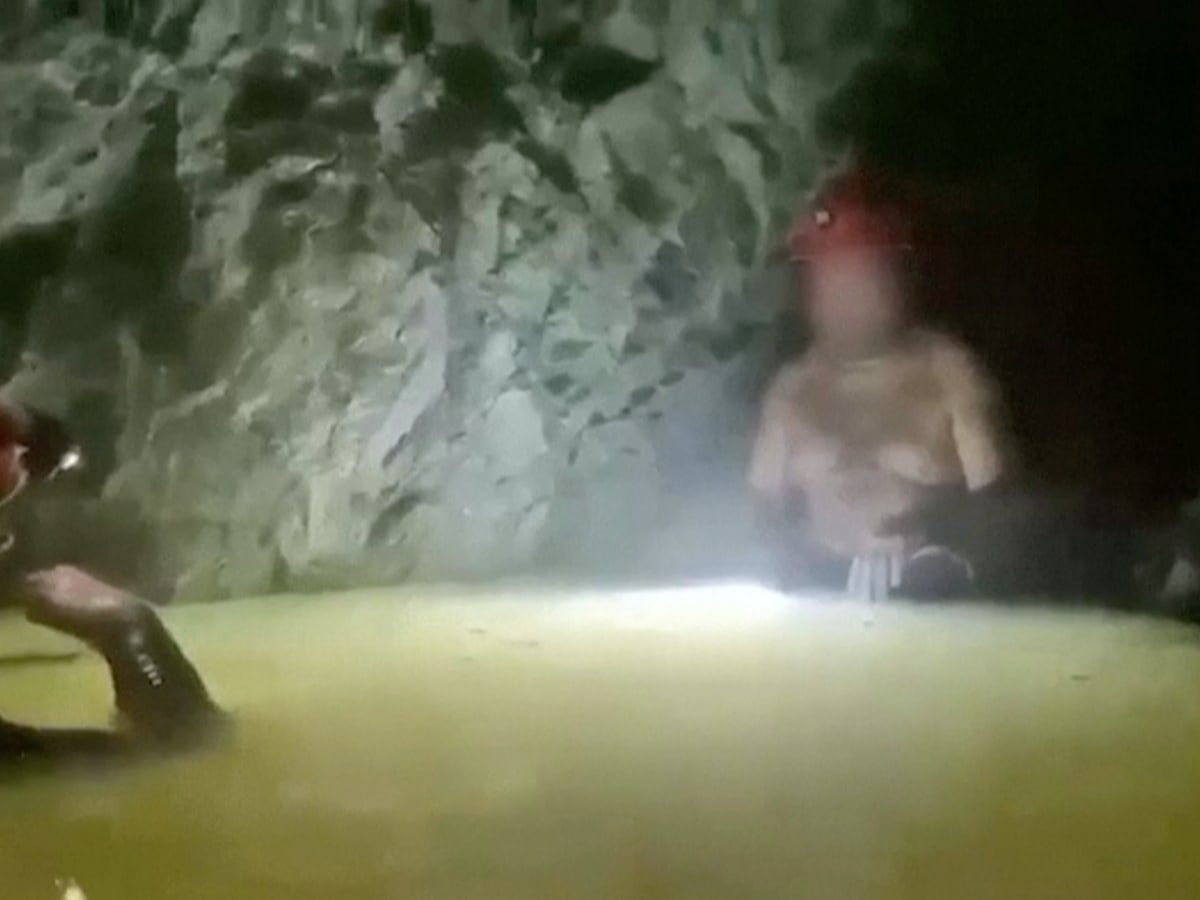 Military rescue divers emerging from flooded mine entrance in Sinaloa, Mexico after successful extraction operation