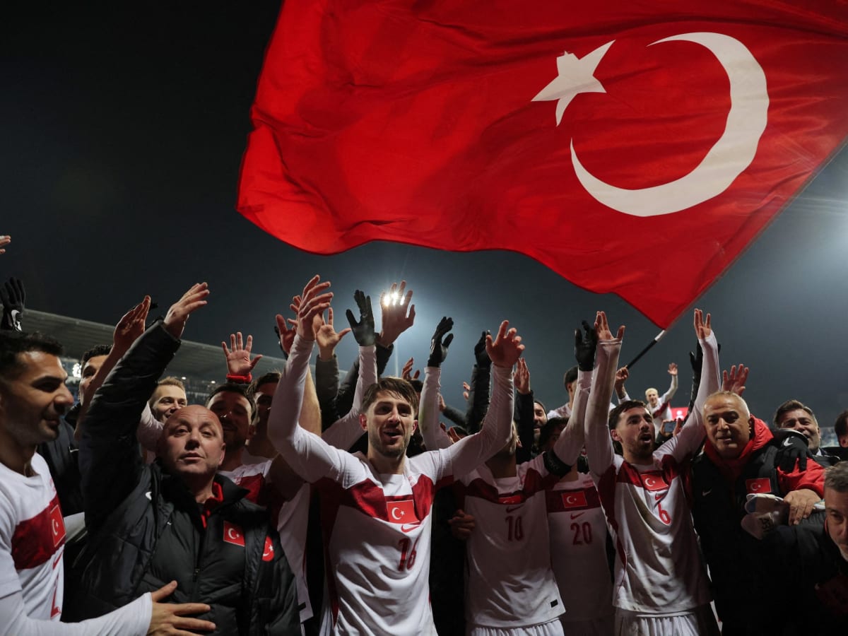 Turkish football players celebrating together on field after qualifying for 2026 World Cup