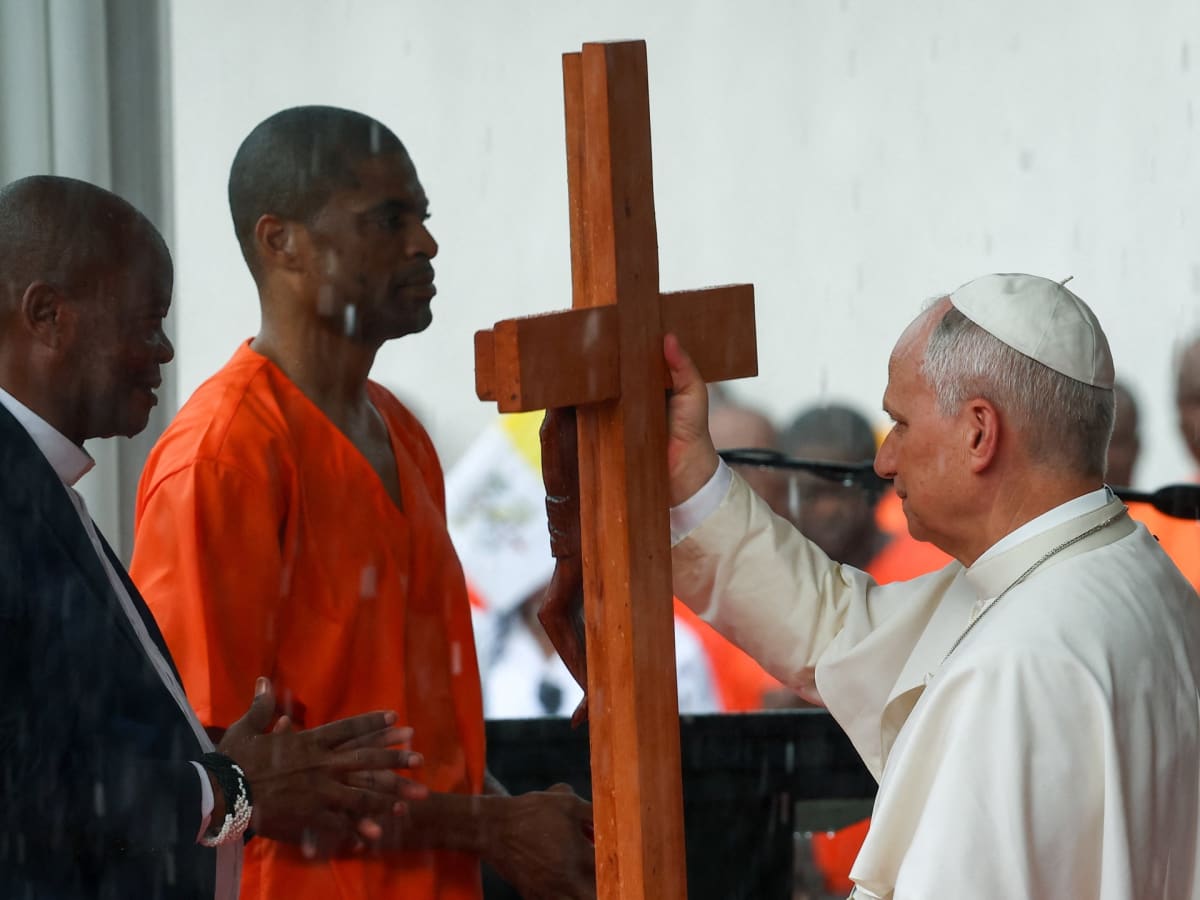 Pope Leo XIV receives a wooden cross from an inmate at Bata Prison in Equatorial Guinea