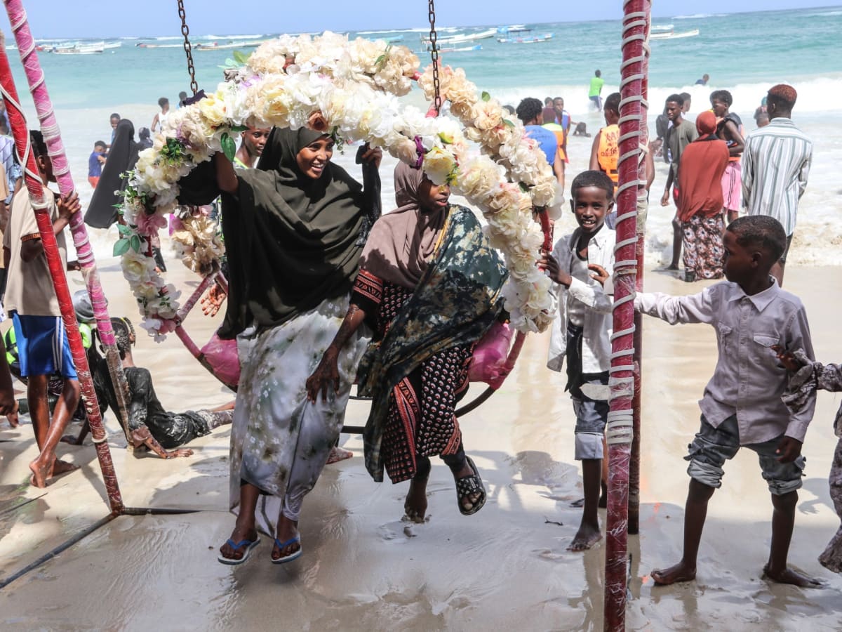 ** Young women on flower-decorated swing at Lido Beach in Mogadishu during Eid celebrations