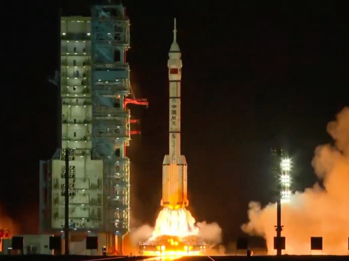 ** Shenzhou-23 rocket launching into blue sky carrying Hong Kong's first astronaut to space station