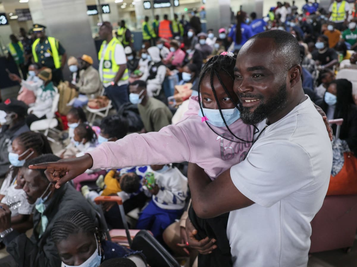 ** Ghanaian Foreign Minister greeting evacuated citizens at Accra International Airport arrival terminal