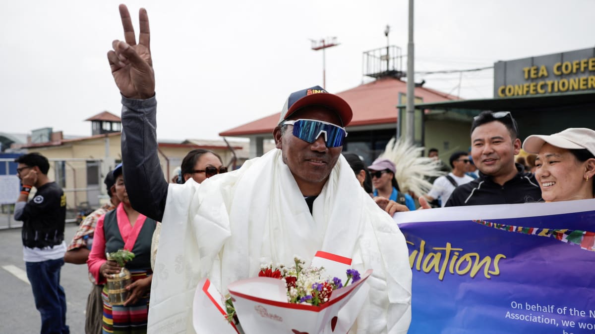 Kami Rita Sherpa in climbing gear on snowy mountain peak celebrating record-breaking Everest summit