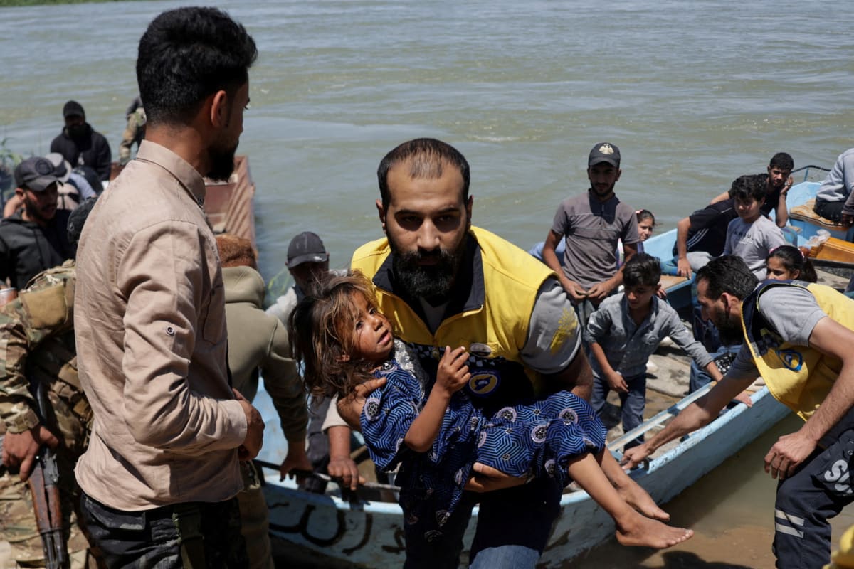 Rescue workers pulling stranded farmers to safety through floodwaters in eastern Syria