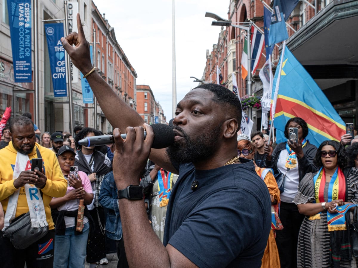 ** People gathered at peaceful protest vigil in Dublin holding signs calling for justice and equality