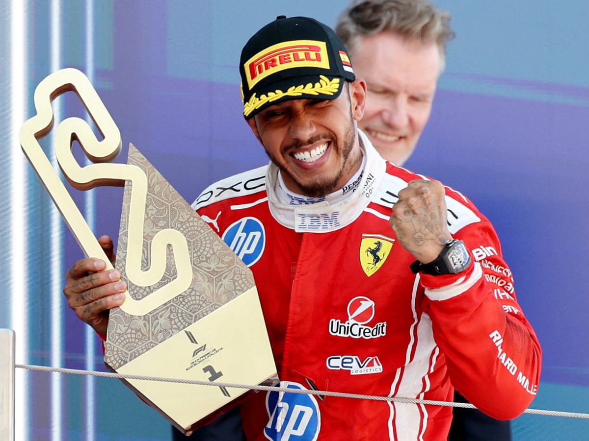 Lewis Hamilton celebrates with trophy after winning Barcelona Grand Prix for Ferrari