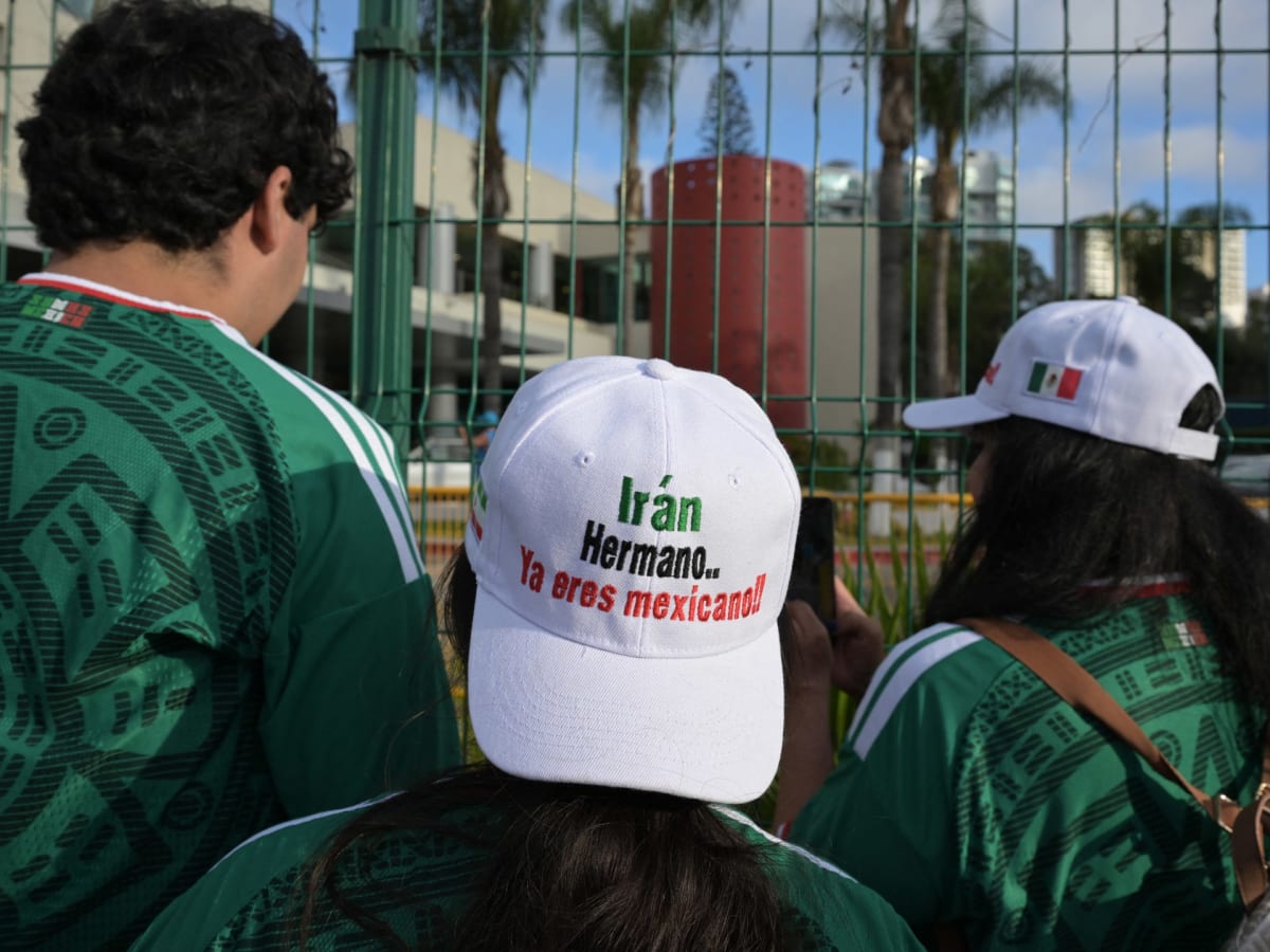 Mexican soccer fans wearing caps welcoming Iranian national team players outside hotel in Tijuana