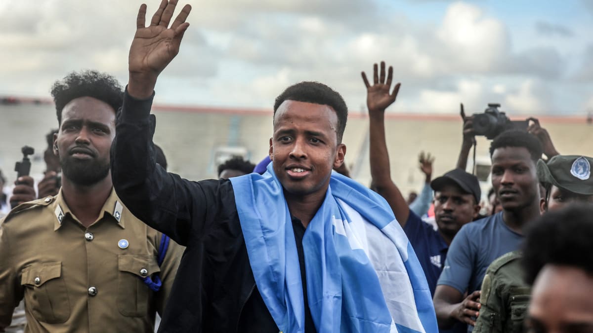 ** Somali referee Omar Artan waving to celebrating crowds at Mogadishu airport arrival