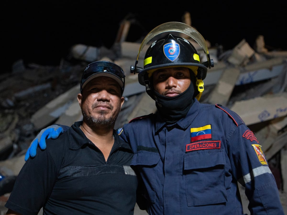 ** Jesus Garcia in firefighting gear embracing his father Jose outside their collapsed apartment building