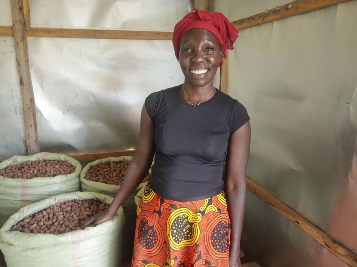 Lucy Everlyn Atim standing in her store surrounded by harvested shea nuts in Uganda