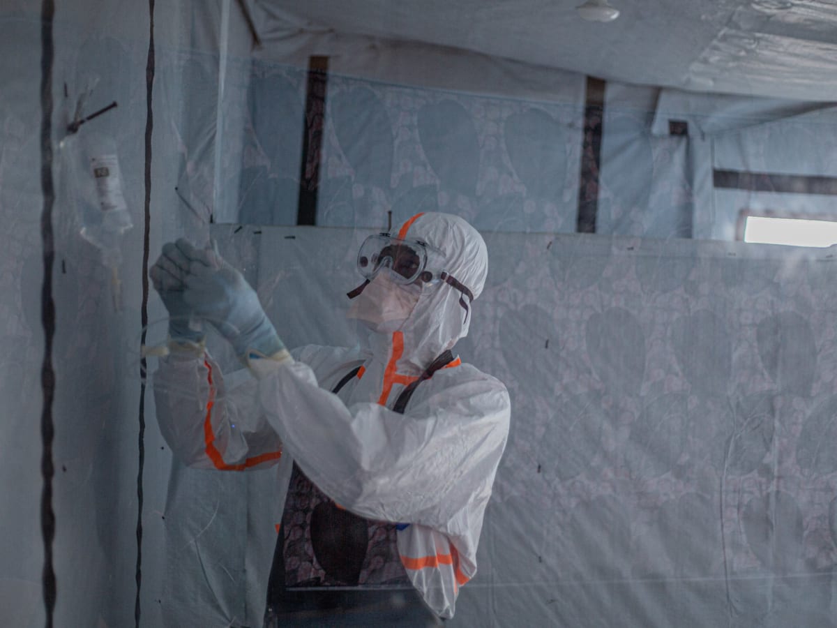 Healthcare worker in protective gear receiving Ebola vaccine injection in Democratic Republic of Congo