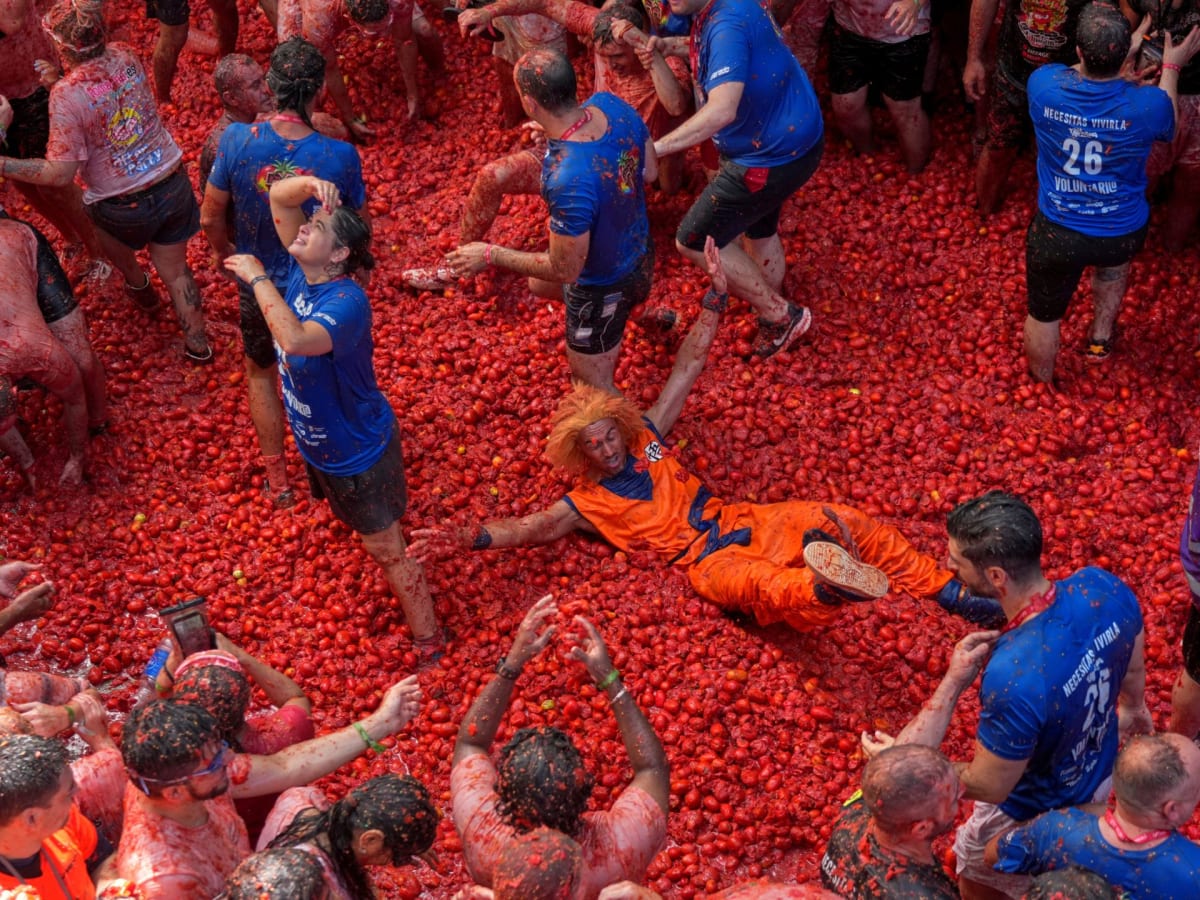 Crowds of festival-goers covered in red tomato pulp during Spain's La Tomatina celebration