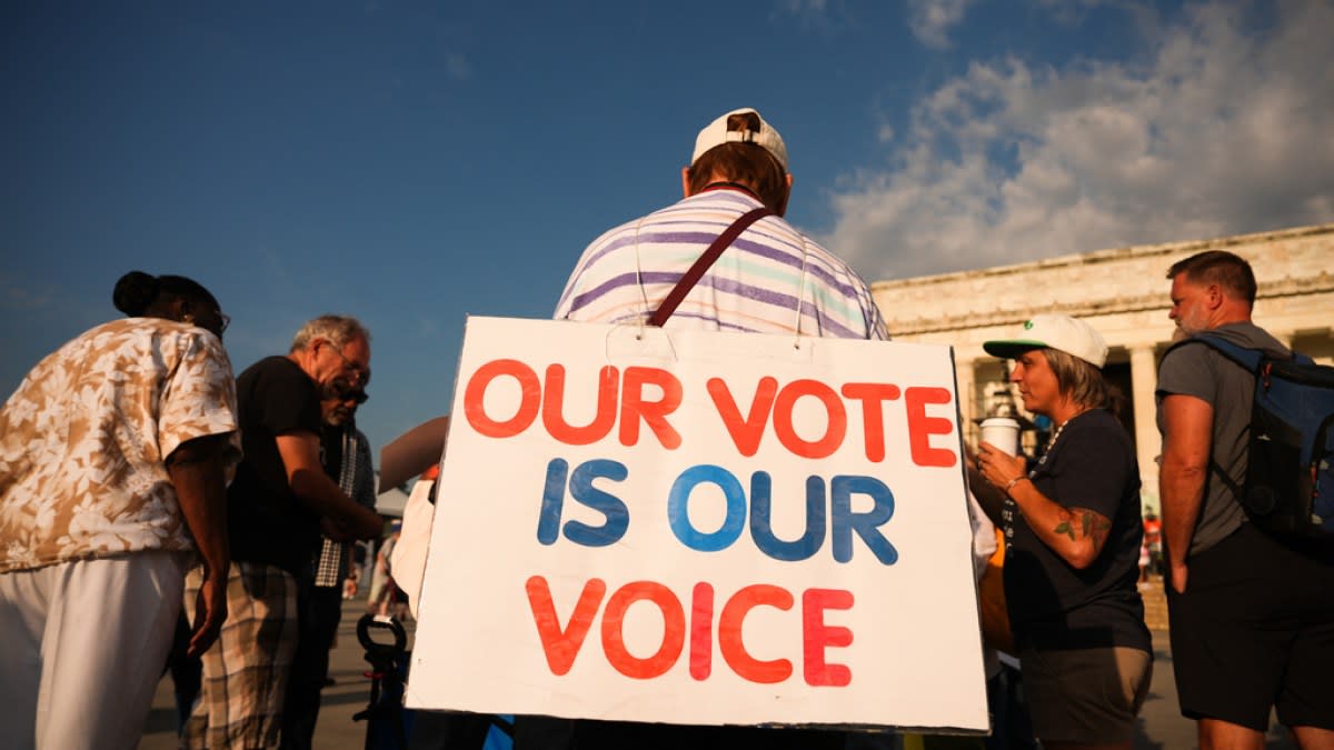 Diverse crowd of thousands gathered at Lincoln Memorial holding voting rights signs