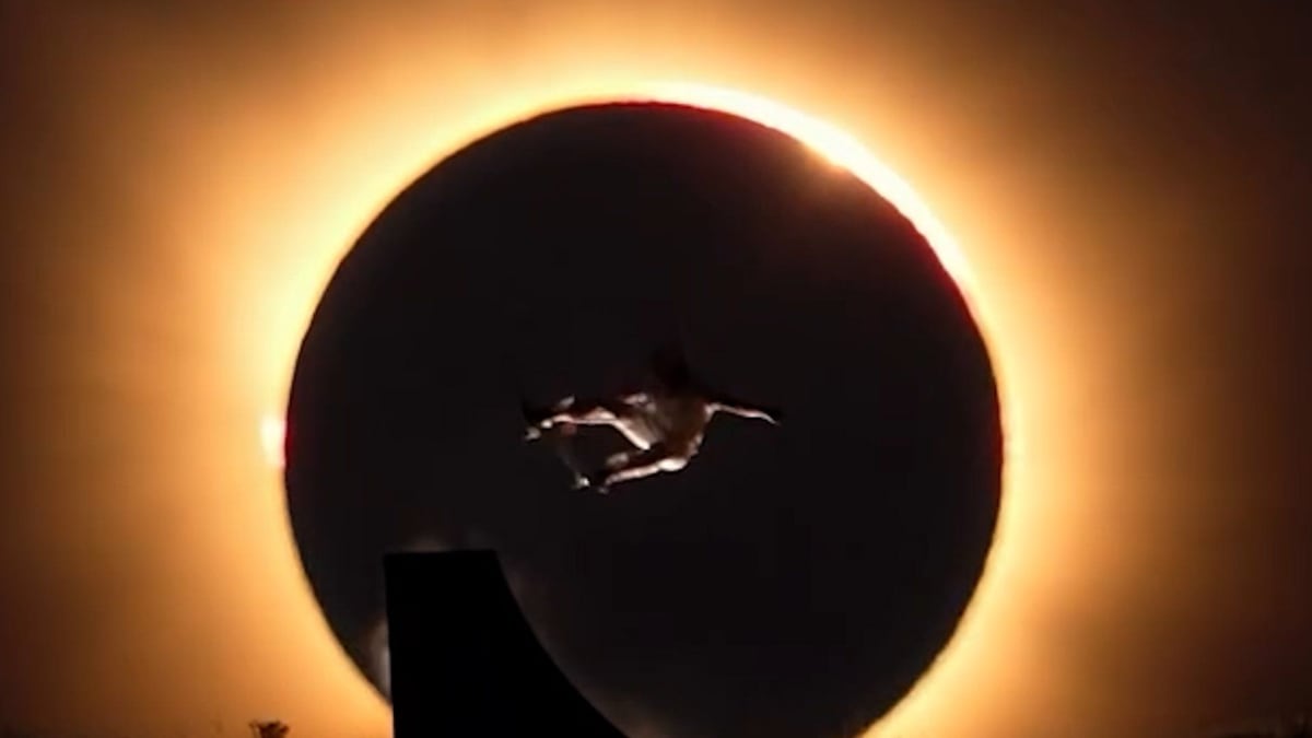 Spanish skateboarder Danny León jumping during solar eclipse with darkened sun visible behind