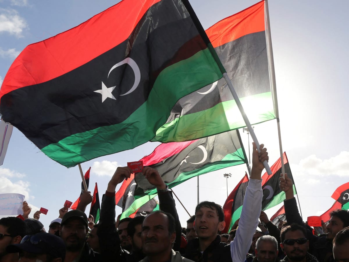 Libyan citizens waving national flags during public demonstration supporting national unity in Benghazi