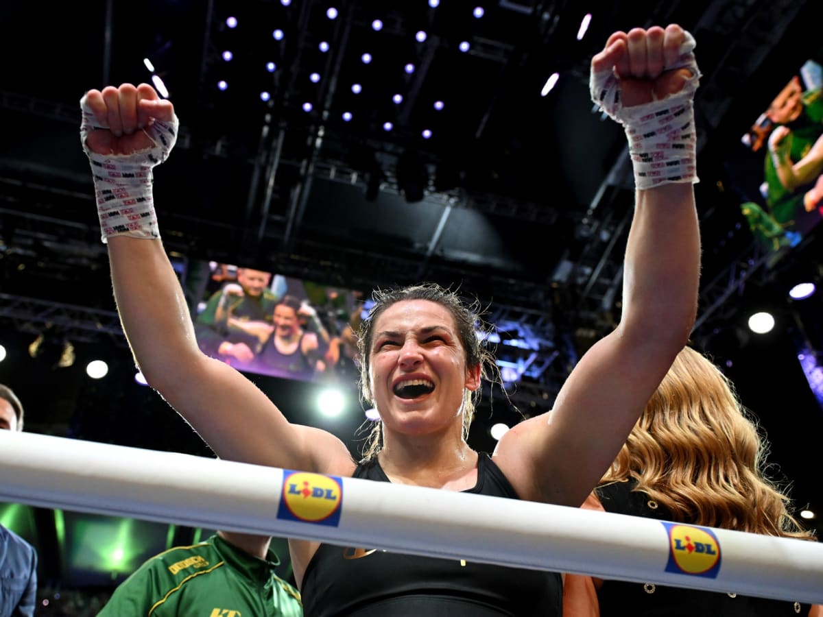 Katie Taylor raises her arms in victory inside boxing ring at Croke Park Dublin