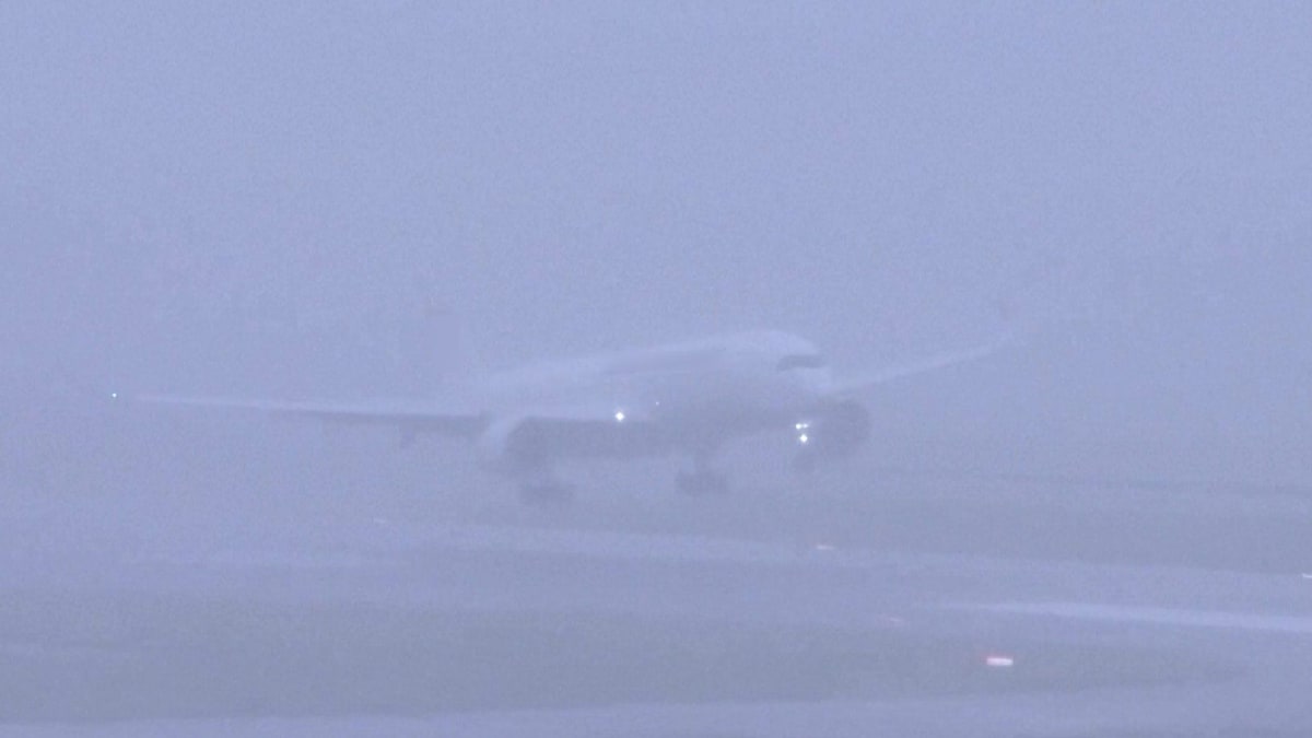 Commercial aircraft approaching runway in stormy weather conditions with heavy winds and rain
