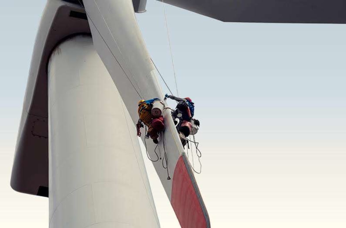 ** Wind turbine blades against blue sky, representing renewable energy innovation and recyclable composite materials