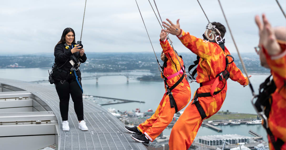 Bungy jumper mid-leap over scenic New Zealand landscape captured on iPhone camera