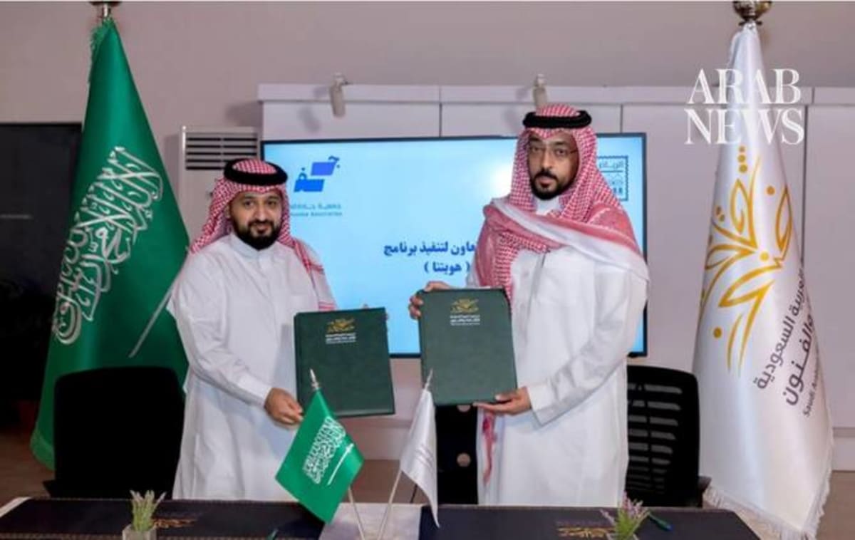 Two Saudi officials shaking hands after signing arts program cooperation agreement in Riyadh