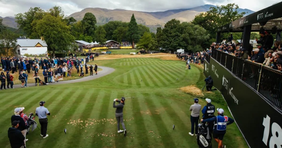 Golf fans watching tournament play at Millbrook Resort with Queenstown mountains in background