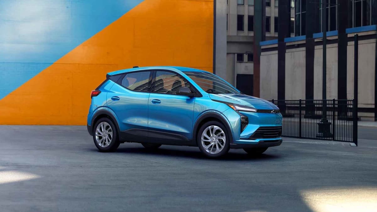 Silver 2027 Chevrolet Bolt compact electric vehicle parked on city street