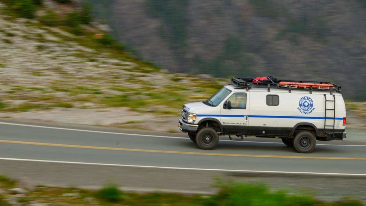 Bellingham Mountain Rescue volunteers navigate steep snowy mountainside carrying rescue equipment and litter