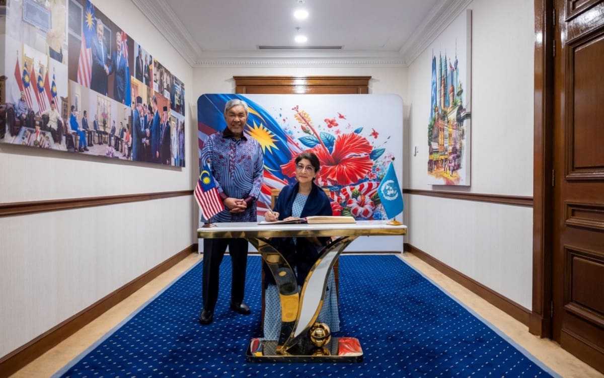 Malaysian and United Nations officials shake hands during space technology partnership announcement meeting
