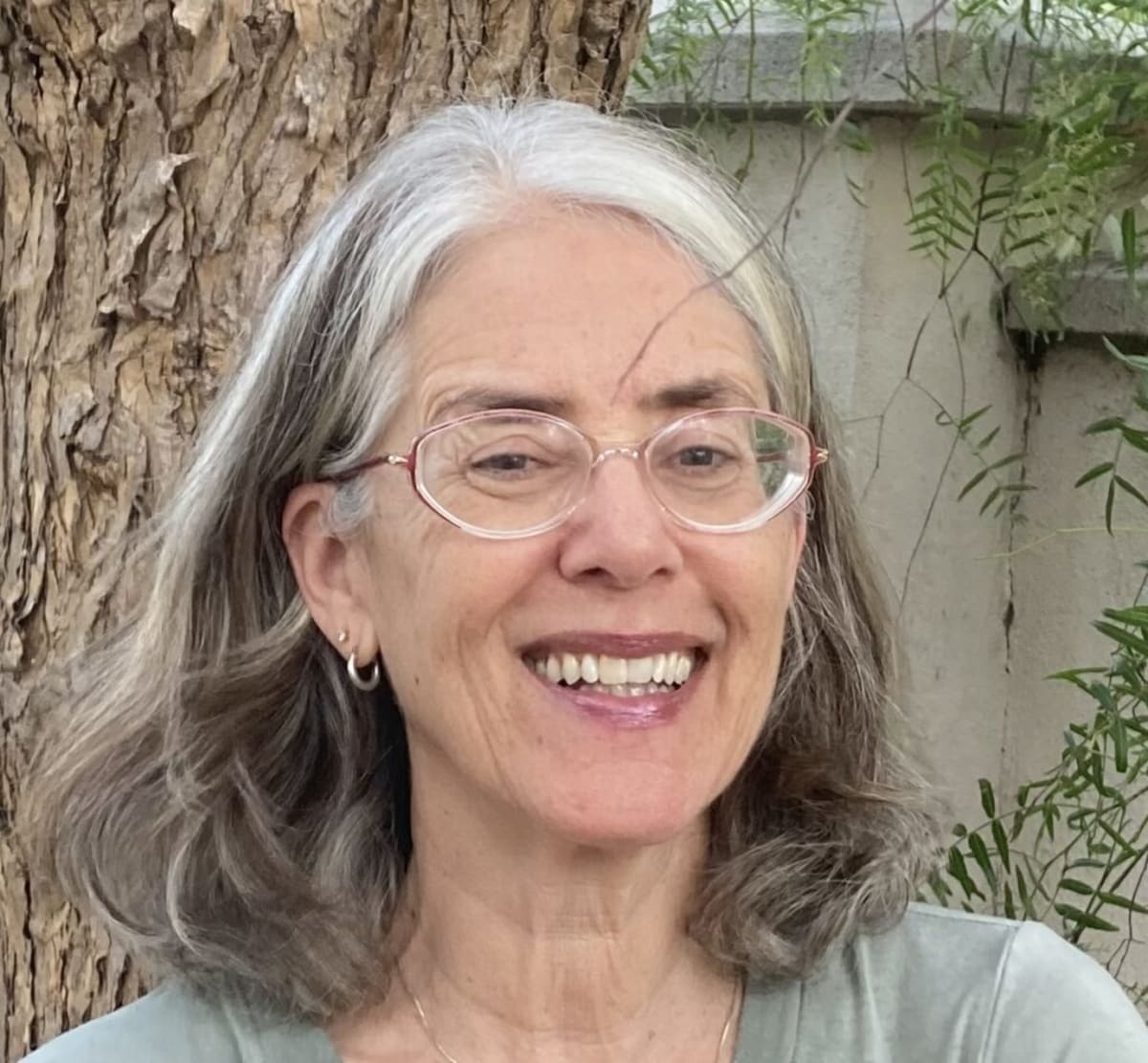 Smiling older woman hiking outdoors enjoying active lifestyle after cancer recovery and treatment