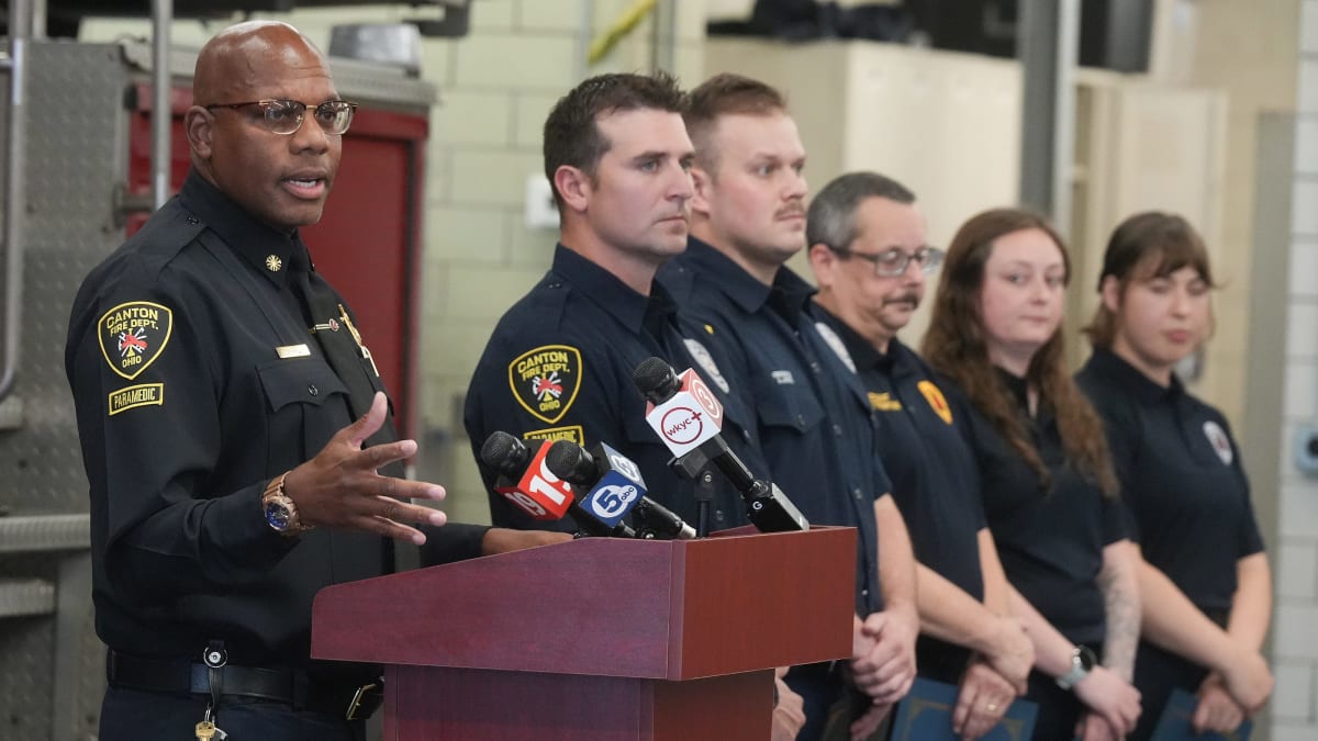 Firefighters in uniform being honored at ceremony for heroic water rescue in Canton, Ohio