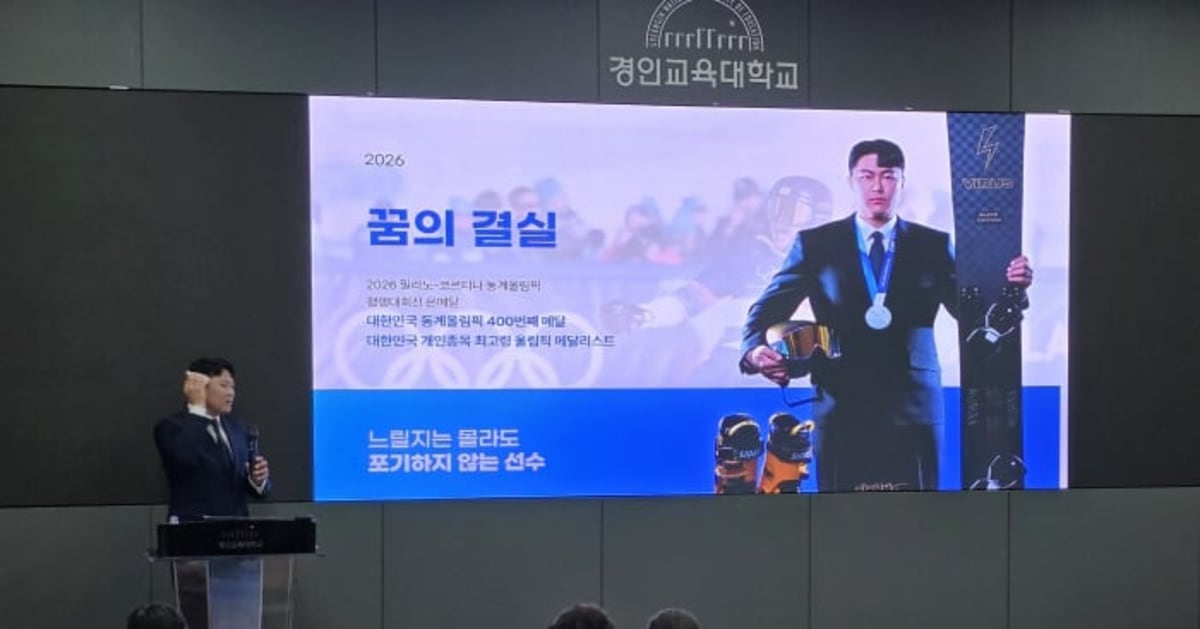 Olympic snowboarder Kim Sang-kyum smiling with group of Korean high school students holding his silver medal