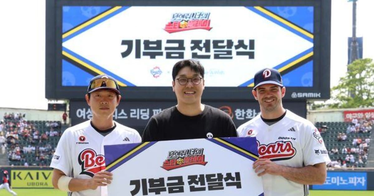 Baseball players and game company representative pose with donation ceremony display at stadium