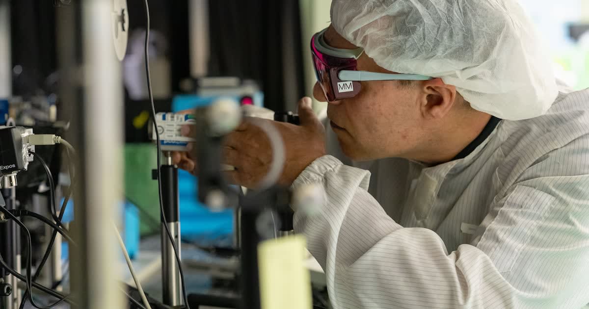 Physicist Mirzaie Mohammad examining advanced laser equipment at research facility in Gwangju, South Korea