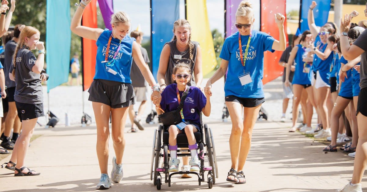 ** Children with disabilities enjoying outdoor summer camp activities with volunteer counselors at Camp Blessing Texas