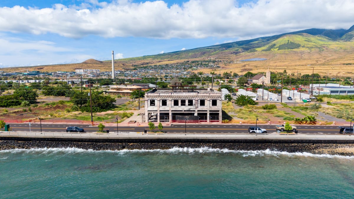 Newly rebuilt homes with green lawns line a Lahaina street three years after wildfires