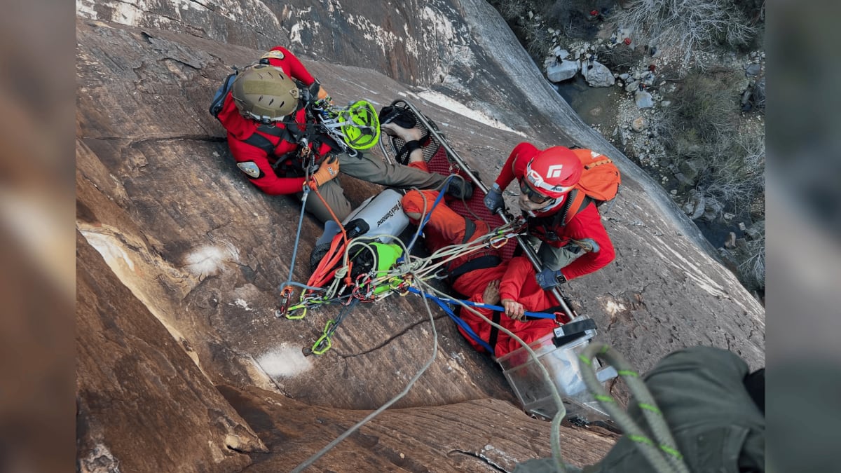 Search and rescue team preparing injured climber in litter on Red Rocks sandstone wall