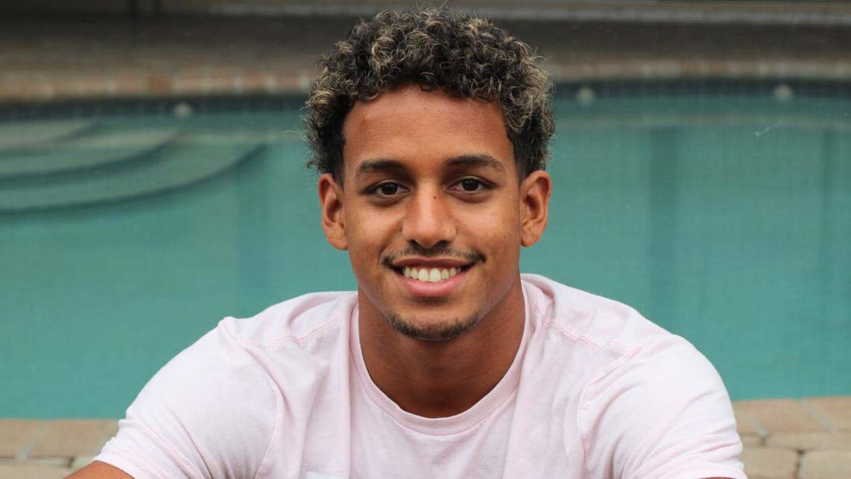 Marcus Johnson celebrates poolside after breaking national breaststroke record at NJCAA championships